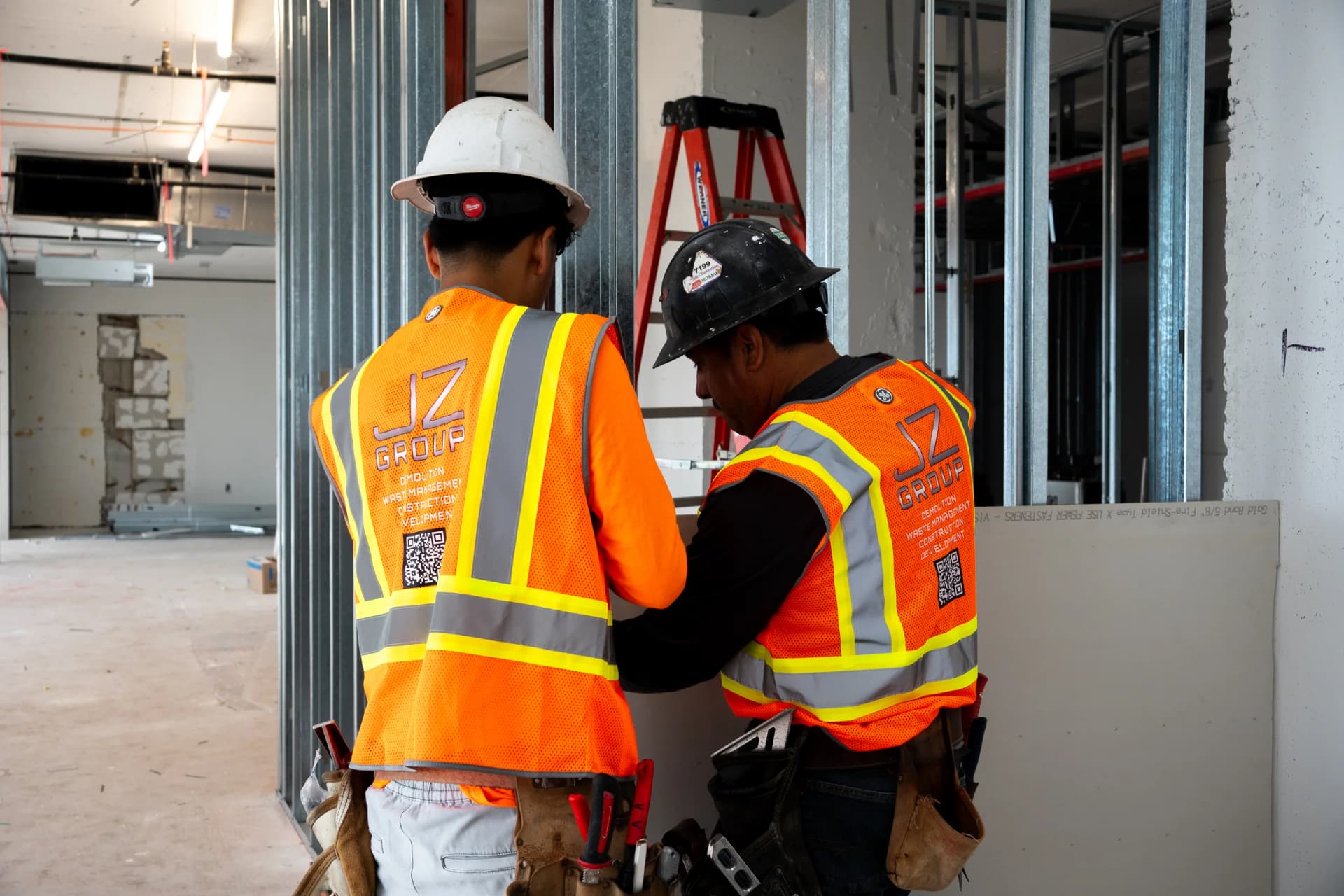 Two JZ workers coordinating drywall work at 100 Biscayne